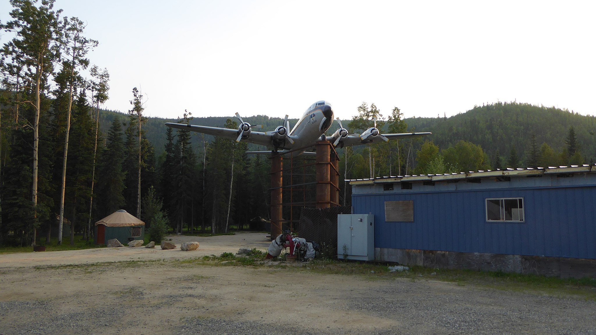 A DC6 aircraft previously owned by Everts Air Cargo on display at Chena Hot Springs, AK. Landed on a dirt airstrip and hoisted on top of 30-foot poles for display.