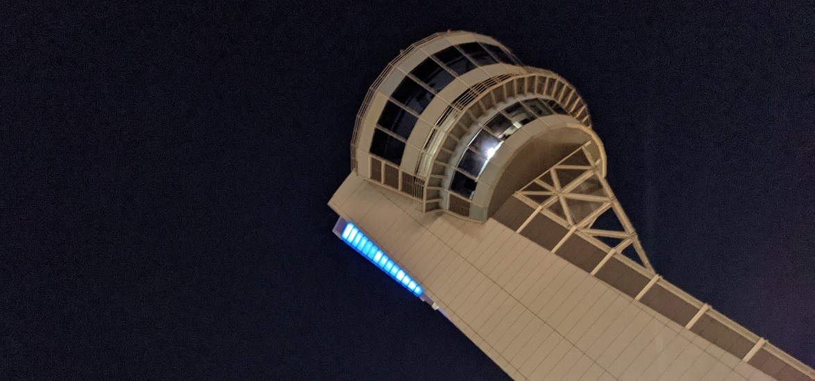 Dark night sky with the bright control tower framed at an angle